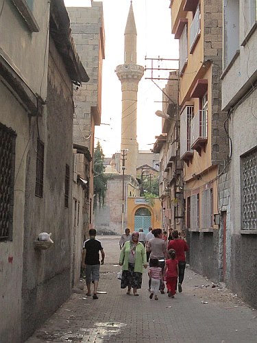 An alley, with a mosque's minaret in the background.